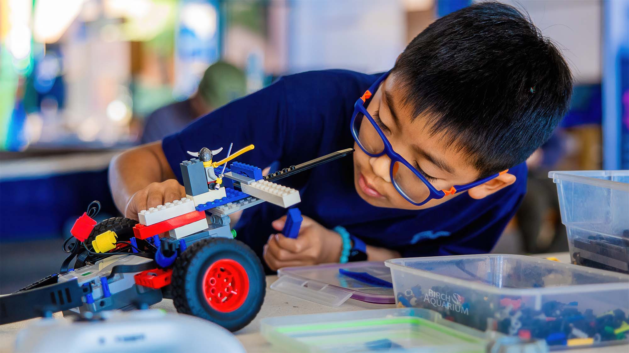 Player building a LEGO robot with red wheels